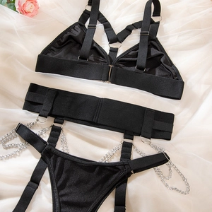 Détails à plat d'un ensemble lingerie punk noir avec chaînes en métal sur satin