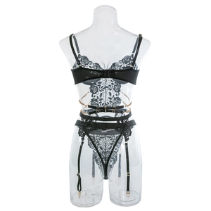 Detail of black lace lingerie set with gold metal chain straps and floral appliques