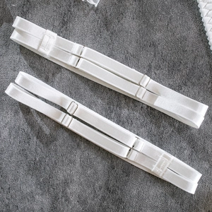 Detail of adjustable white elastic lingerie straps with silver metal hooks and sliders
