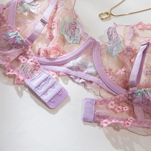 Détail de broderie florale sur soutien-gorge en dentelle lilas avec agrafage à trois rangs