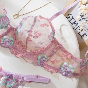 Détail d'un soutien-gorge en tulle lilas avec broderies florales complexes roses et vertes