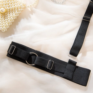 Détail de bretelles élastiques noires avec anneaux métalliques sur fond de satin blanc