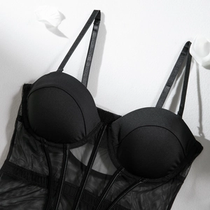 Detail view of black corset bodysuit with mesh patchwork and sheer fishbone structure