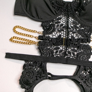 Detail of black lace bodysuit featuring gold metal chains and rose floral embroidery