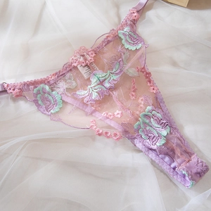 Détail de broderie sur string en dentelle lavande avec motifs floraux et liens réglables