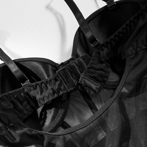 Detail of adjustable straps and sheer mesh lace on a black sexy backless bodysuit