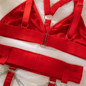 Détail d'un ensemble lingerie punk rouge avec anneaux en métal et chaînes