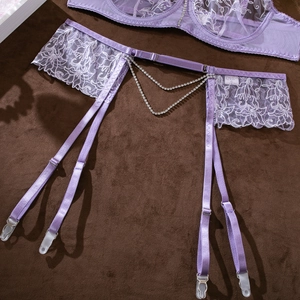 Detailed close-up of purple lace garter belt with luxury dangling rhinestone chains