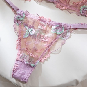 Gros plan détaillé d'un string en dentelle lilas avec broderies et boucle en métal réglable