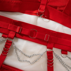 Détail de lingerie corset rouge punk avec anneaux métalliques et doubles chaînes