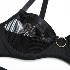 Detail of black mesh bodysuit featuring underwire support and gold ring accents