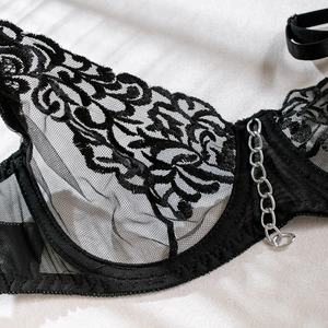 Nahaufnahme des schwarzen Netz-Bodys mit Spitze, Stickerei und silberner Metallkette