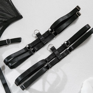 Detail of adjustable black elastic leg garters with silver metal rings and mesh fabric