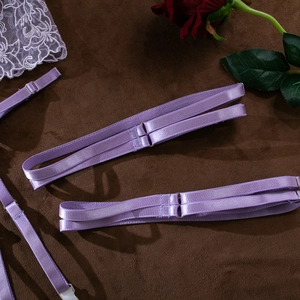 Detail of adjustable purple elastic straps with silver metal buckles on lace lingerie