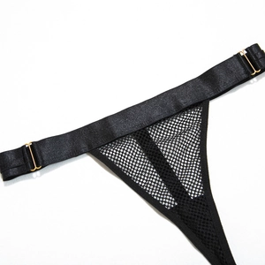 Detail of mesh bodysuit featuring black netting fabric and gold T-shaped metal buckle