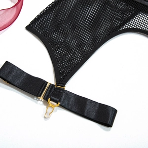 Detailed macro view of black mesh fabric with satin straps and golden metal buckles