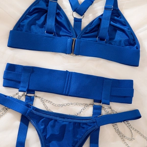 Détail d'un ensemble de lingerie bleu roi avec chaînes métalliques argentées