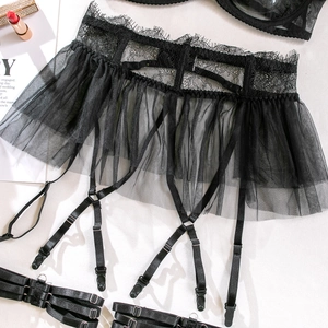 Détail de la jupe porte-jarretelles en dentelle noire avec mesh plissé et clips