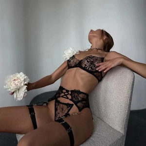 Detailed view of floral lace bodysuit with gold chain straps and cut-out waist design