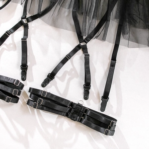 Détail d'un porte-jarretelles noir en tulle avec sangles élastiques et clips réglables