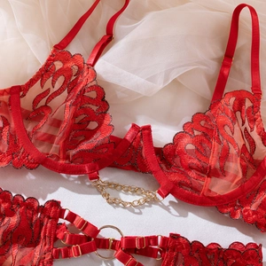 Close-up of red lace bodysuit with flame embroidery and gold chain metal accents