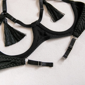 Détail de lingerie noire sexy avec des pampilles et des boucles métalliques réglables