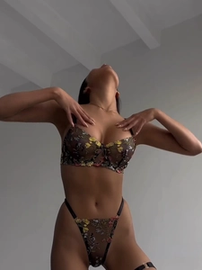 Détail d'un ensemble de lingerie en résille avec broderies florales et armatures