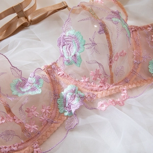 Détail de la broderie florale sur soutien-gorge en maille avec dentelle lilas et menthe