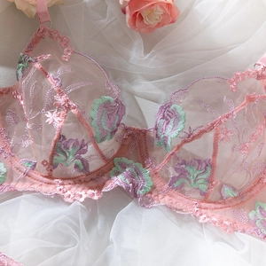 Close-up of pink lace bra featuring purple floral embroidery and scalloped edges