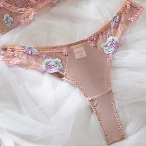 Détail du string en mesh rose avec broderie florale de roses multicolores et bords festonnés
