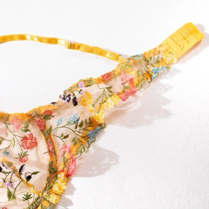 Détail du soutien-gorge jaune en maille avec broderie florale et bretelles réglables