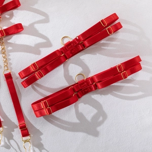 Close-up of red elastic garter belt straps with gold metal buckles and flame embroidery