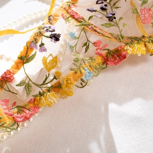 Vue détaillée de la broderie florale sur tulle transparent avec bordure en dentelle