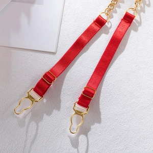 Close-up of red elastic straps with golden metal buckles and chain for the corset suit