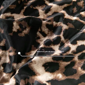 Detailed view of soft milk silk leopard print fabric with black and brown patterns