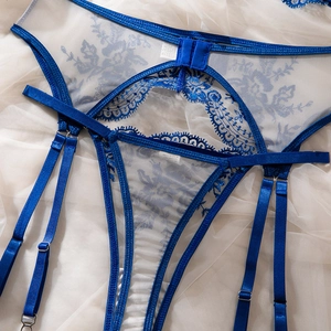 Flat lay detail of royal blue lace lingerie set with floral embroidery and satin straps