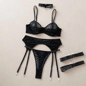 Detail of black leopard flocking on sheer mesh bodysuit with silver metal buckles