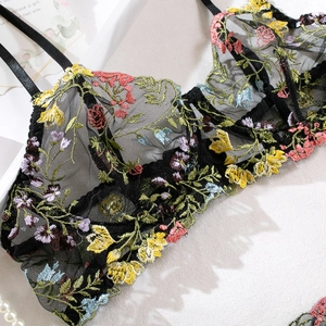 Gros plan détaillé du soutien-gorge en résille noire avec broderies florales multicolores