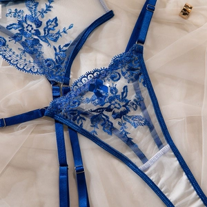 Close-up of royal blue floral lace embroidery with satin straps and bow on bodysuit