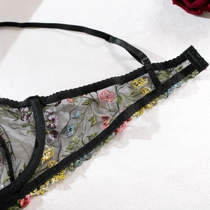 Détail macro du soutien-gorge en résille noire avec broderie florale et bretelles réglables