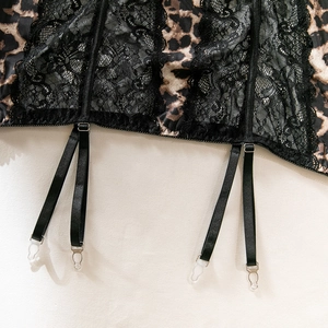 Detail of adjustable garter belts with metal buckles on leopard print and lace lingerie