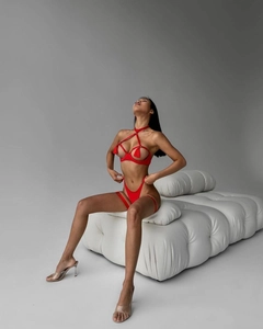 Close-up of red hollow-out lingerie set with tassel details and metal ring connector