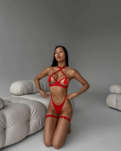 Close-up of red hollow lingerie set with fringe details and metal ring accents
