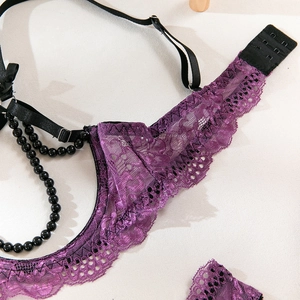 Détail d'un soutien-gorge en dentelle violette avec chaîne perlée noire et métal