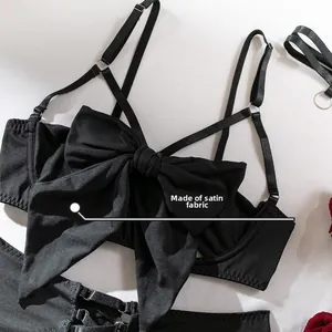 Detail eines schwarzen Dessous-Sets mit großer Satinschleife und glattem Satinstoff