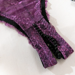 Détail de lingerie en dentelle florale violette avec chaînes de perles noires et fente