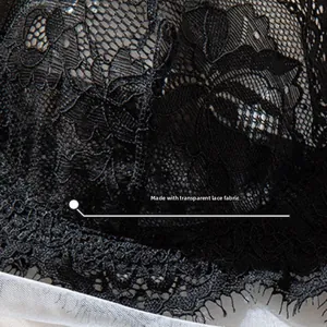 Detail shot of delicate black floral eyelash lace fabric with sheer texture and embroidery