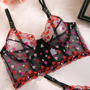 Detail of sheer black lace corset with heart embroidery and pearl scene decoration