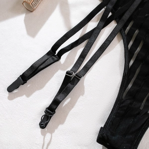 Detail of black elastic garter straps with metal buckles and stripe mesh fabric