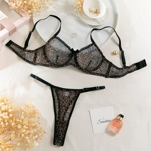 Flat lay of leopard print mesh lingerie set with lace trim and elegant lifestyle props